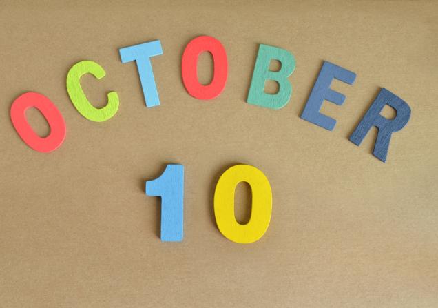 ‘October 10’ written in colourful wooden letters and numbers on a brown background. Image by M.R. Frost via Shutterstock.